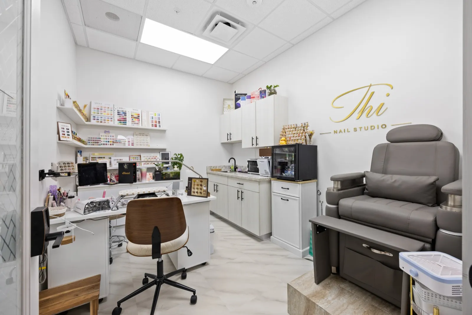 An equipped nail studio with built-in cabinetry at Revive Salon Collective